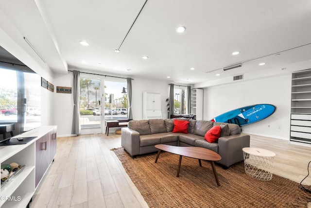 living room with light wood-style floors, baseboards, recessed lighting, and visible vents