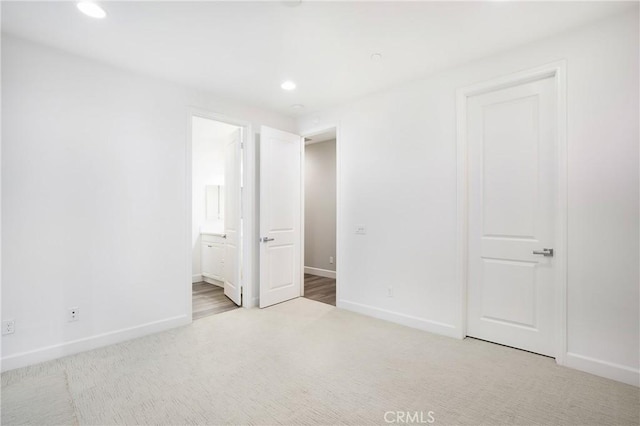 unfurnished bedroom featuring baseboards, recessed lighting, carpet floors, and connected bathroom