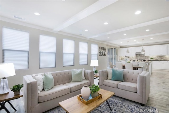 living room featuring visible vents, recessed lighting, light wood-style floors, and beam ceiling