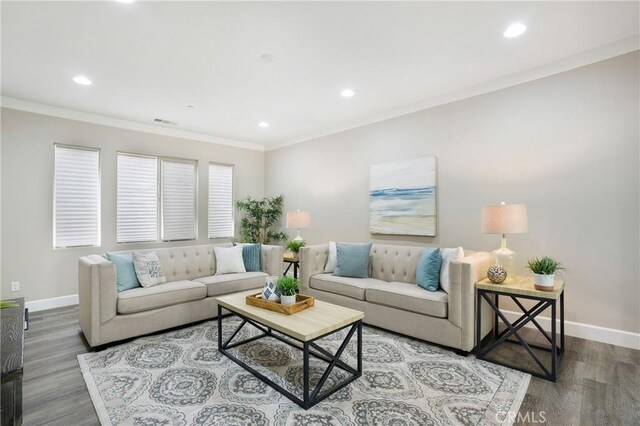 living room featuring recessed lighting, baseboards, ornamental molding, and wood finished floors