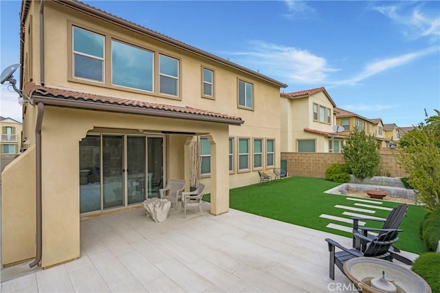 rear view of property with a patio, a fenced backyard, stucco siding, and a tiled roof