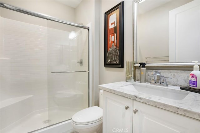 full bathroom with vanity, a stall shower, and toilet