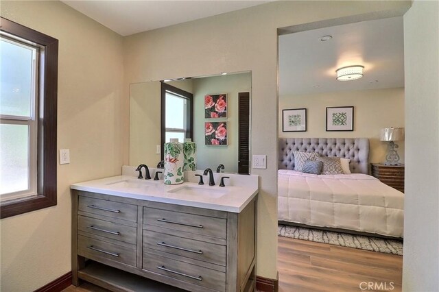 bathroom featuring double vanity, a sink, and wood finished floors
