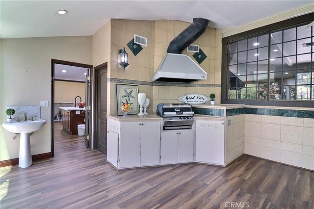 kitchen featuring visible vents, dark wood-style flooring, light countertops, white cabinetry, and exhaust hood