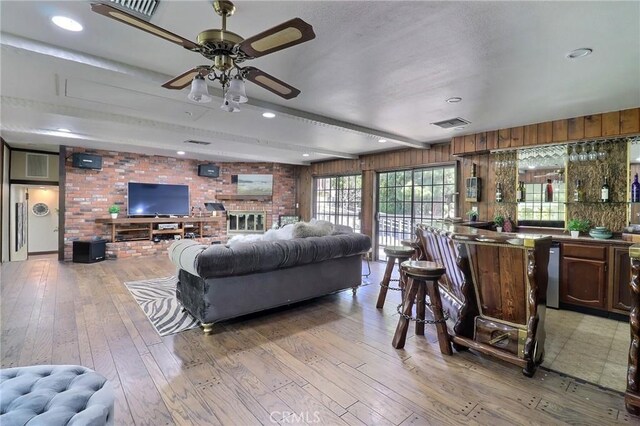 living room featuring visible vents, light wood-style flooring, and ceiling fan