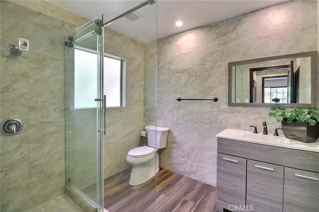full bathroom with tile walls, plenty of natural light, and a shower stall