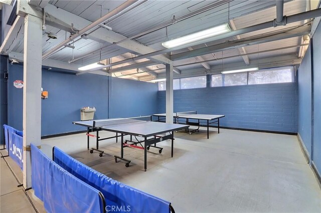 recreation room with concrete flooring and baseboards