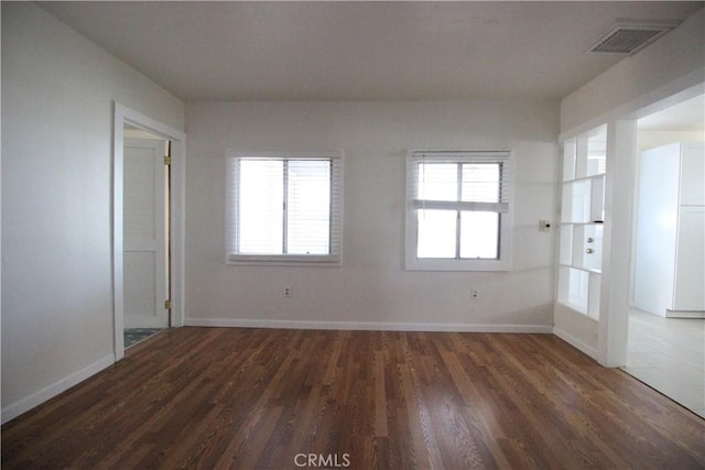 200 E St, Taft, CA 93268 - empty room with baseboards, dark wood-style flooring, and visible vents