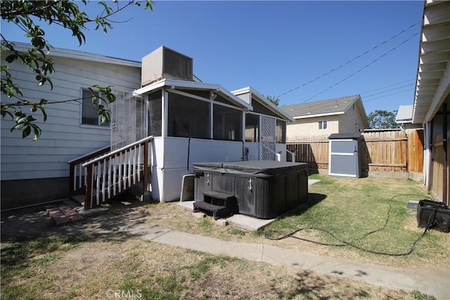 200 E St, Taft, CA 93268 - back of house featuring a fenced backyard, a sunroom, a storage unit, a hot tub, and a yard