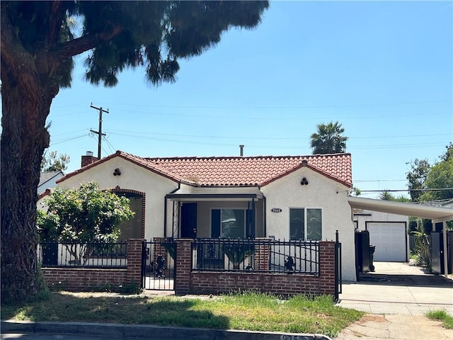 mediterranean / spanish-style home with a fenced front yard, a tiled roof, driveway, and stucco siding
