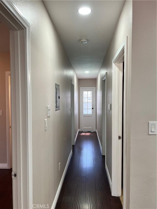 hall featuring baseboards and dark wood finished floors