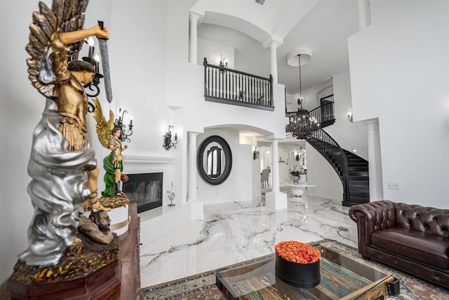 733 Clayburn Ct, Alpine, CA 91901 - living room with a high ceiling, arched walkways, a glass covered fireplace, marble finish floor, and decorative columns
