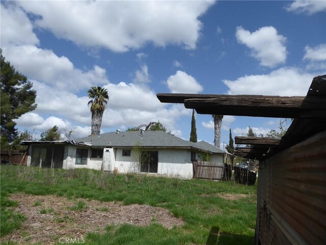 rear view of house with fence and stucco siding