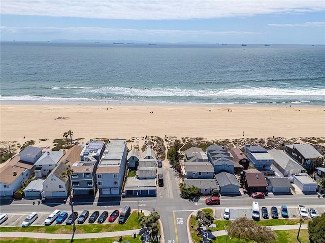 bird's eye view with a water view, a view of the beach, and a residential view