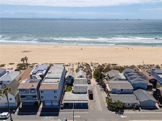 birds eye view of property featuring a water view, a beach view, and a residential view