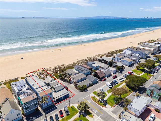 drone / aerial view with a beach view, a residential view, and a water view