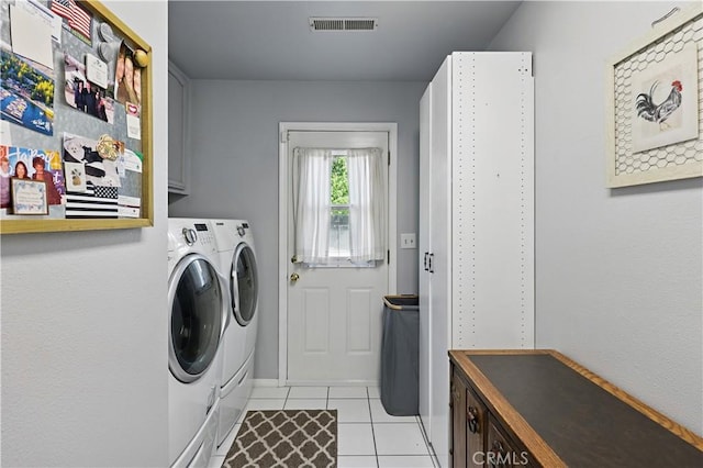 clothes washing area featuring cabinet space, washing machine and clothes dryer, visible vents, baseboards, and light tile patterned flooring