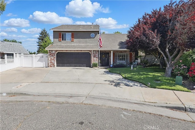 traditional-style home with fence, brick siding, driveway, stucco siding, and a front yard
