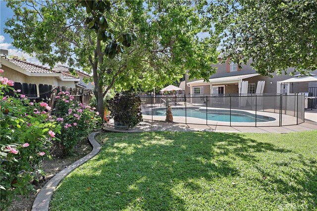 view of swimming pool featuring a fenced backyard, a fenced in pool, and a yard