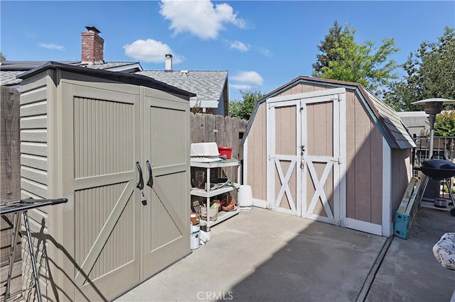 view of shed featuring fence
