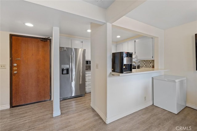 kitchen featuring stainless steel refrigerator with ice dispenser, light countertops, fridge, and light wood-type flooring