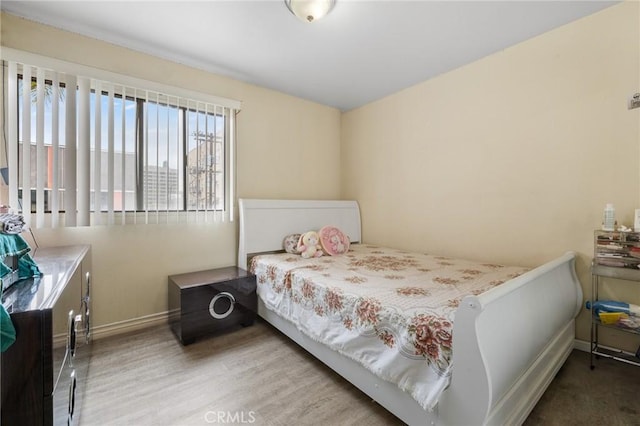 bedroom with baseboards and wood finished floors