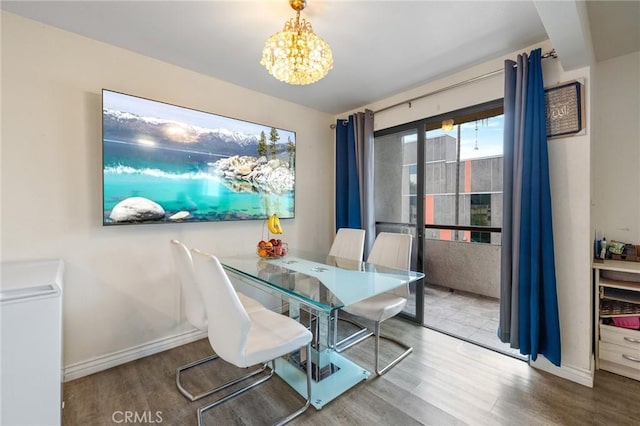 dining area featuring an inviting chandelier, baseboards, and wood finished floors