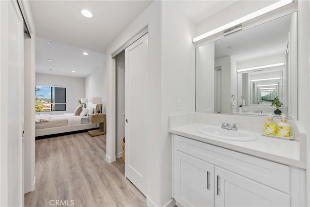 bathroom featuring vanity, ensuite bath, recessed lighting, baseboards, and wood finished floors