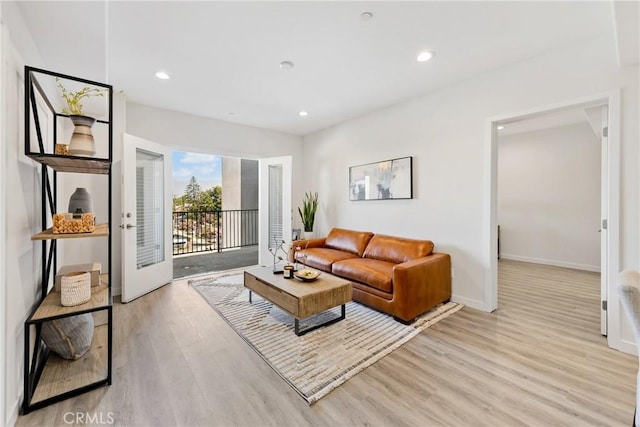 living area featuring light wood-style floors, baseboards, and recessed lighting