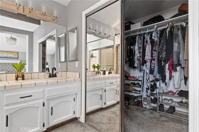 full bath with vanity, a shower stall, and a spacious closet