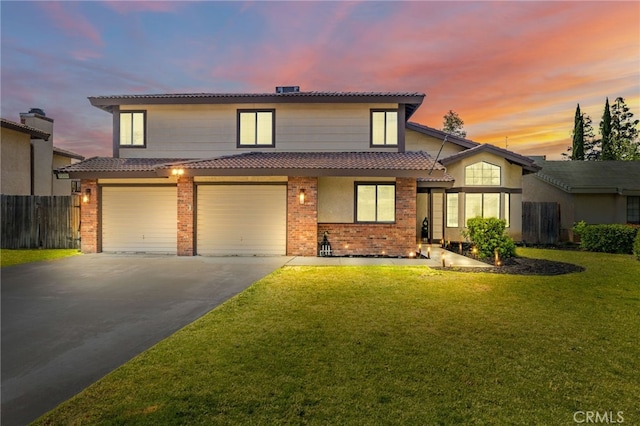 traditional home with fence, brick siding, a front yard, a tiled roof, and driveway