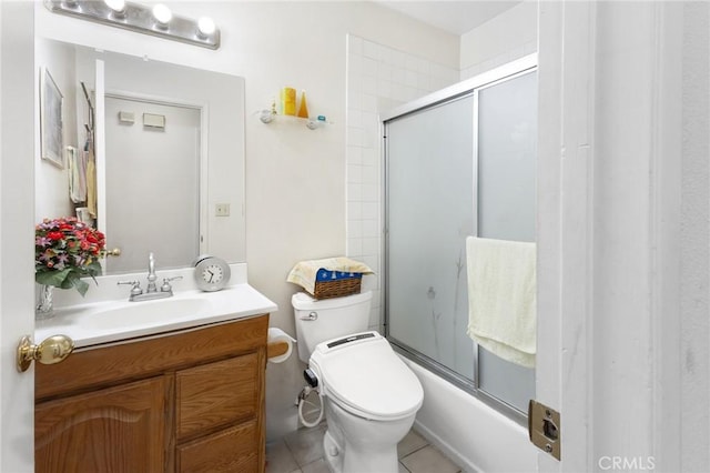 bathroom featuring bath / shower combo with glass door, tile patterned flooring, vanity, and toilet