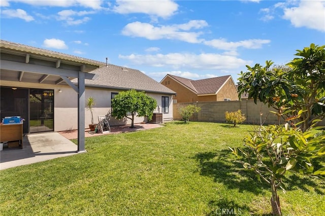 back of property with fence, a patio, stucco siding, and a yard
