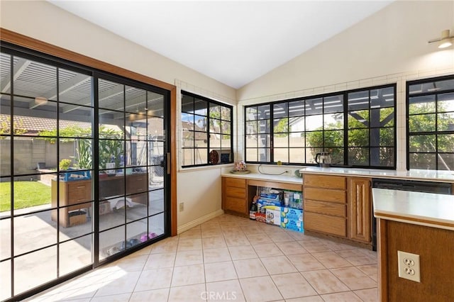 interior space featuring baseboards, light tile patterned flooring, and lofted ceiling