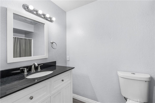 10341 N Loop Blvd, California City, CA 93505 - bathroom featuring vanity, baseboards, and toilet