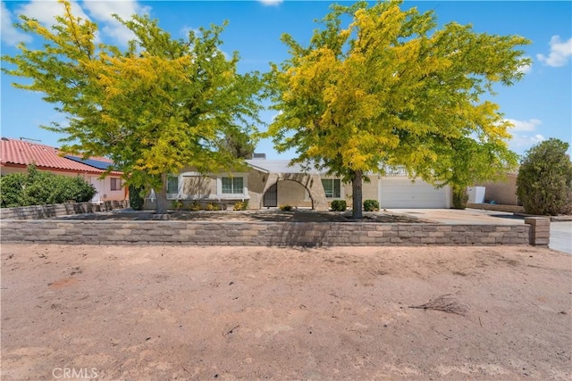 10341 N Loop Blvd, California City, CA 93505 - view of front of home featuring a garage, stucco siding, and driveway