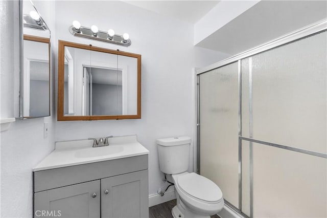 10341 N Loop Blvd, California City, CA 93505 - bathroom featuring vanity, toilet, baseboards, wood finished floors, and a stall shower