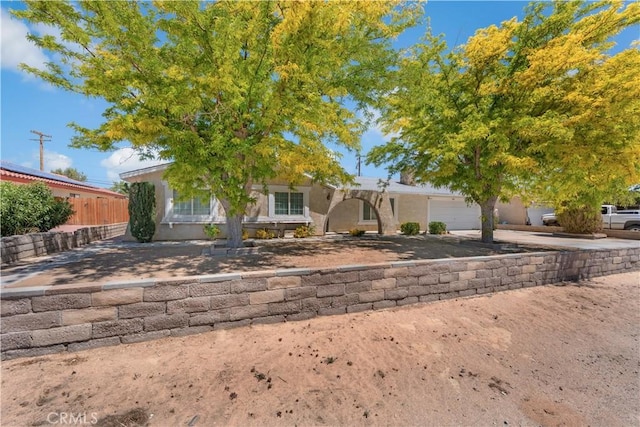 10341 N Loop Blvd, California City, CA 93505 - view of front of property with an attached garage, fence, stucco siding, and concrete driveway