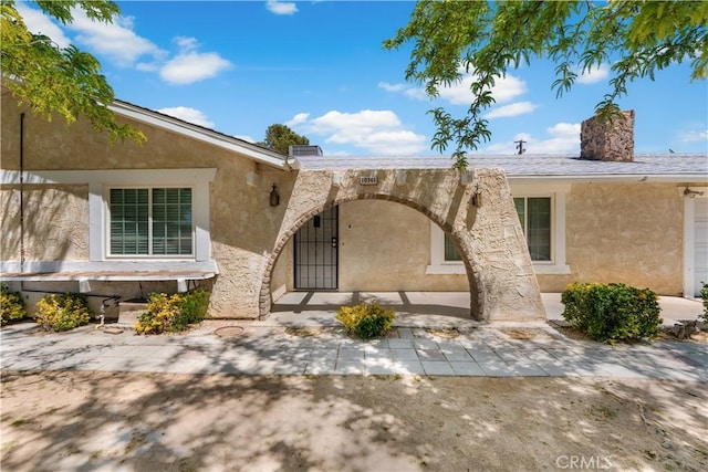 10341 N Loop Blvd, California City, CA 93505 - doorway to property with stucco siding and a chimney