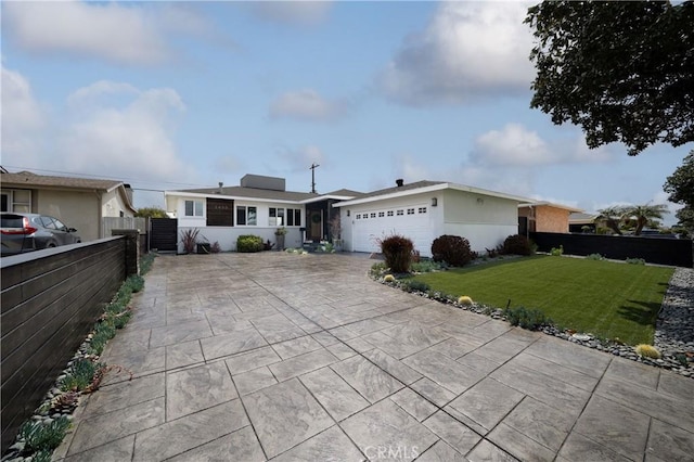 single story home featuring fence, an attached garage, driveway, and a front lawn