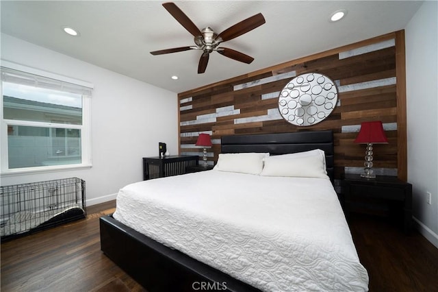 bedroom featuring baseboards, dark wood finished floors, and wooden walls