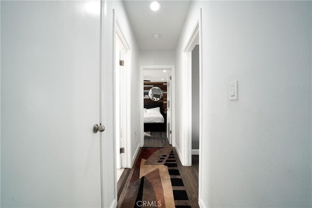hallway with baseboards, recessed lighting, and dark wood finished floors