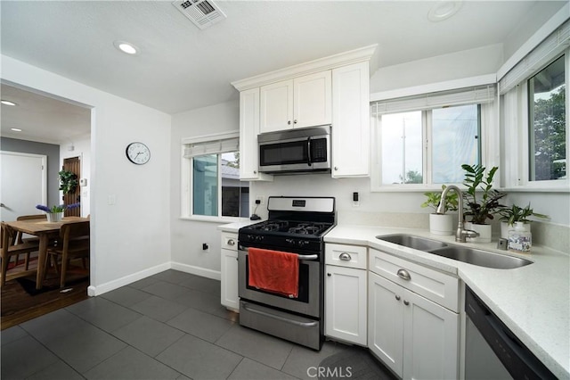 kitchen with visible vents, a sink, light countertops, and stainless steel appliances