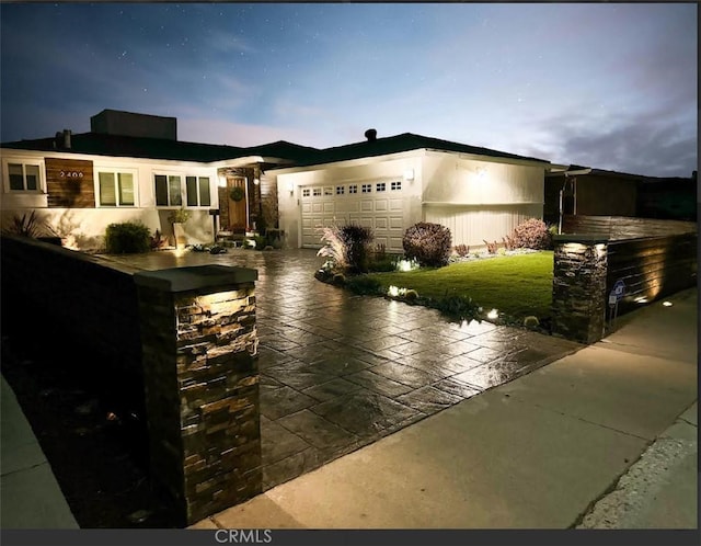 view of front facade with concrete driveway and a garage