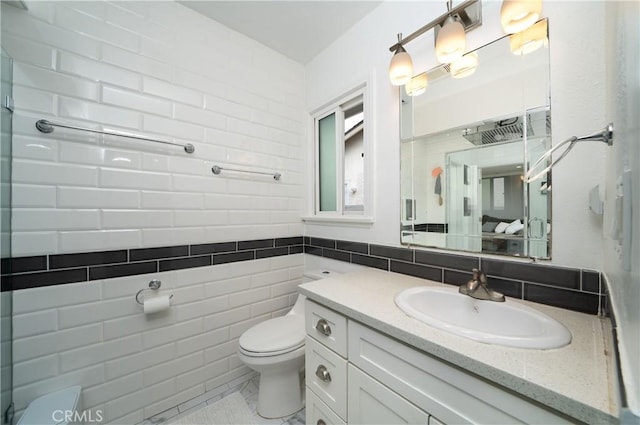full bathroom featuring vanity, toilet, and tile walls