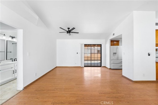 unfurnished living room featuring visible vents, light wood finished floors, ceiling fan, and baseboards