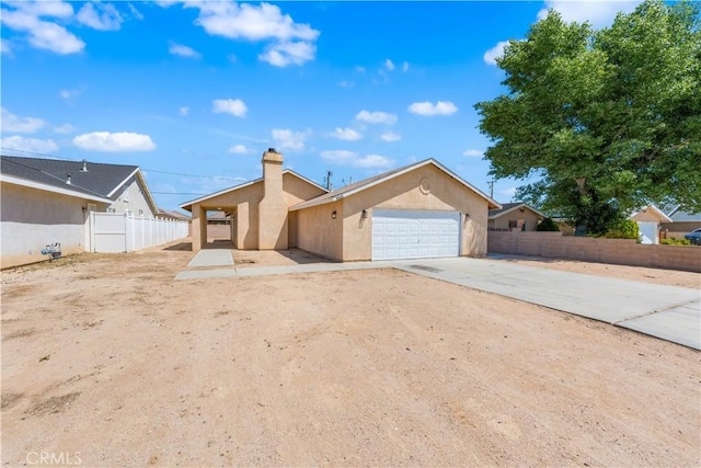 view of front of house featuring fence, stucco siding, driveway, and a garage