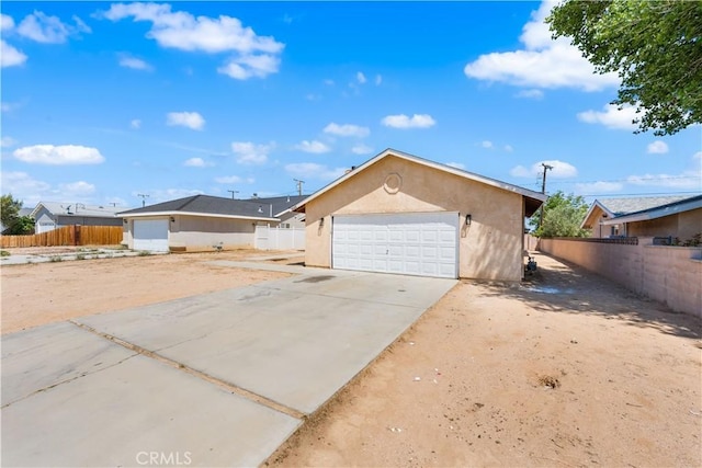 view of front of property with fence, stucco siding, and driveway