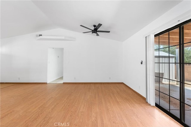 empty room featuring baseboards, light wood-style flooring, ceiling fan, and vaulted ceiling