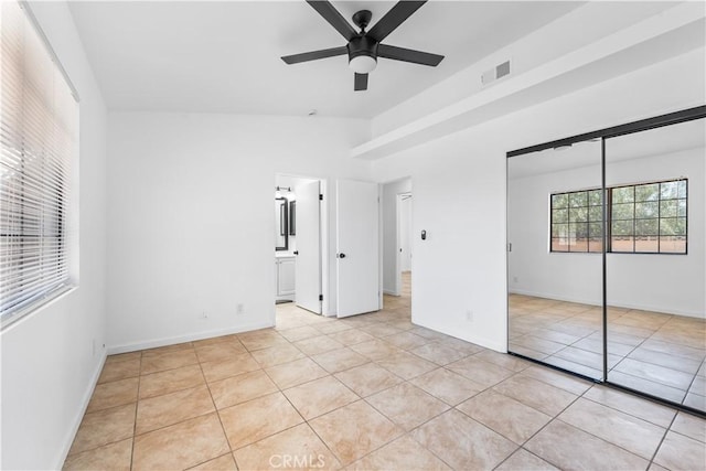 unfurnished bedroom with light tile patterned floors, ceiling fan, a closet, and visible vents